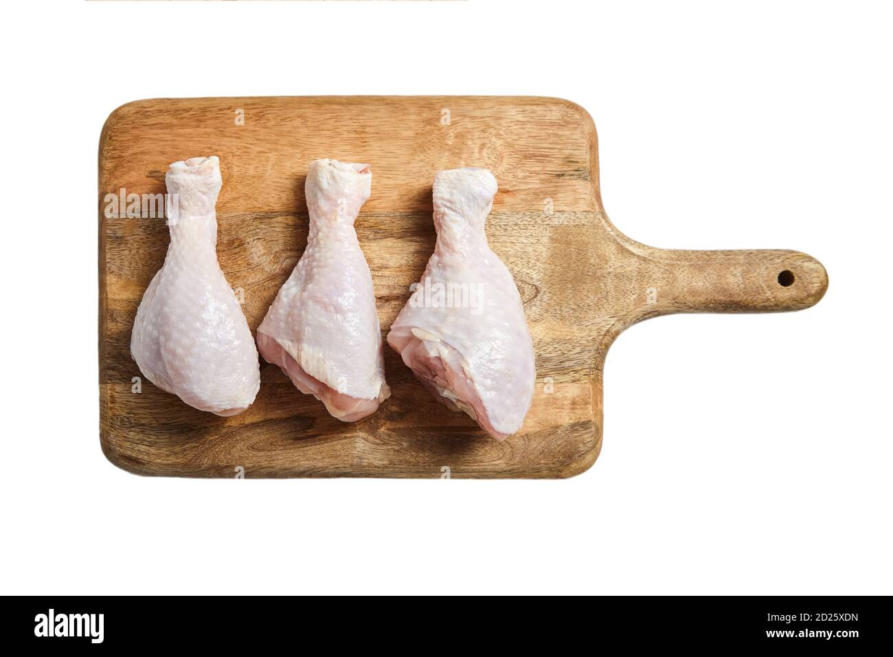 Tre zampe di pollo crude con la pelle che giace su un tagliere di legno. Carni fresche non cotte di pollame isolate su fondo bianco. Vista dall'alto Foto Stock