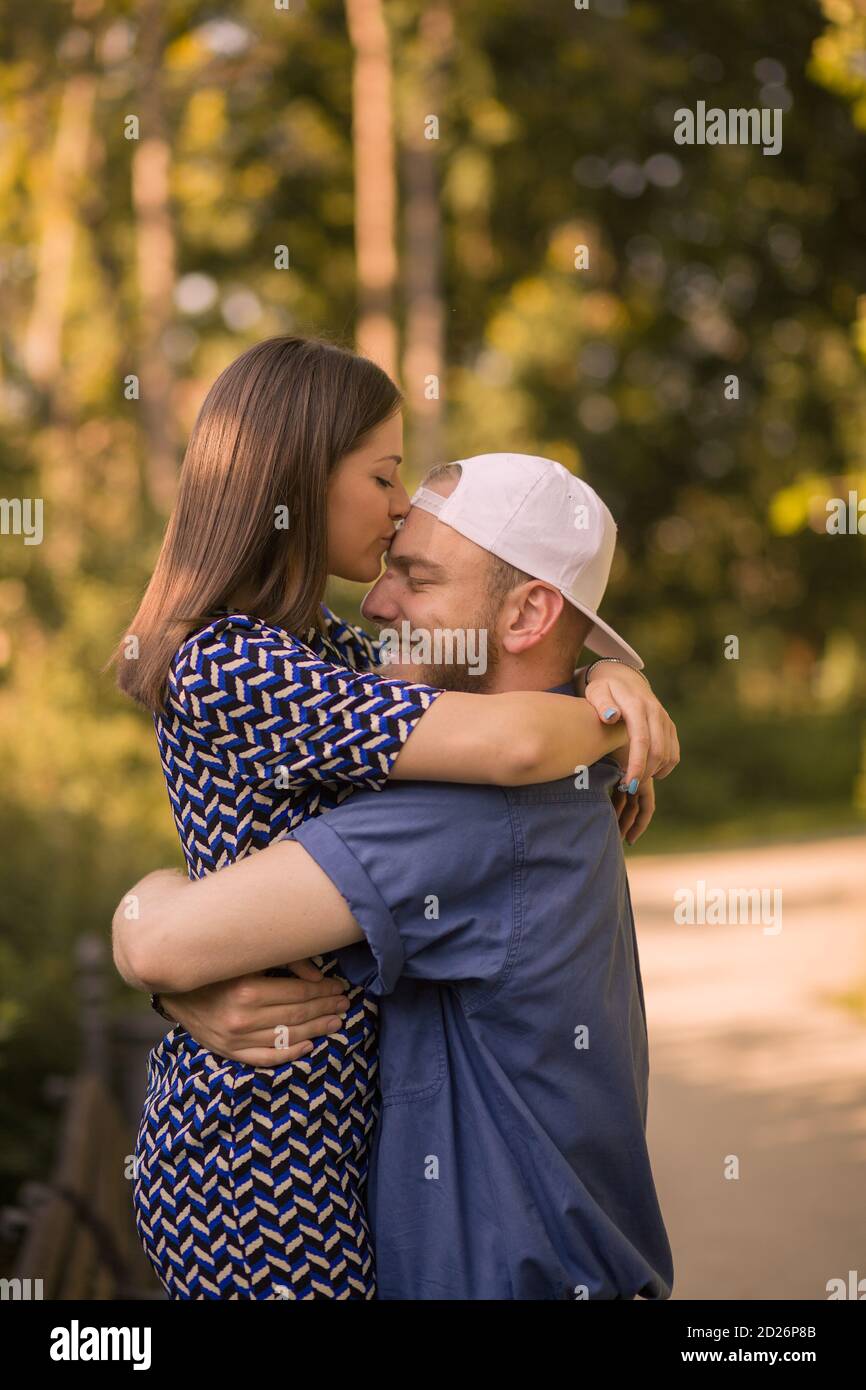 La ragazza bacia l'uomo teneramente in fronte. Foto Stock