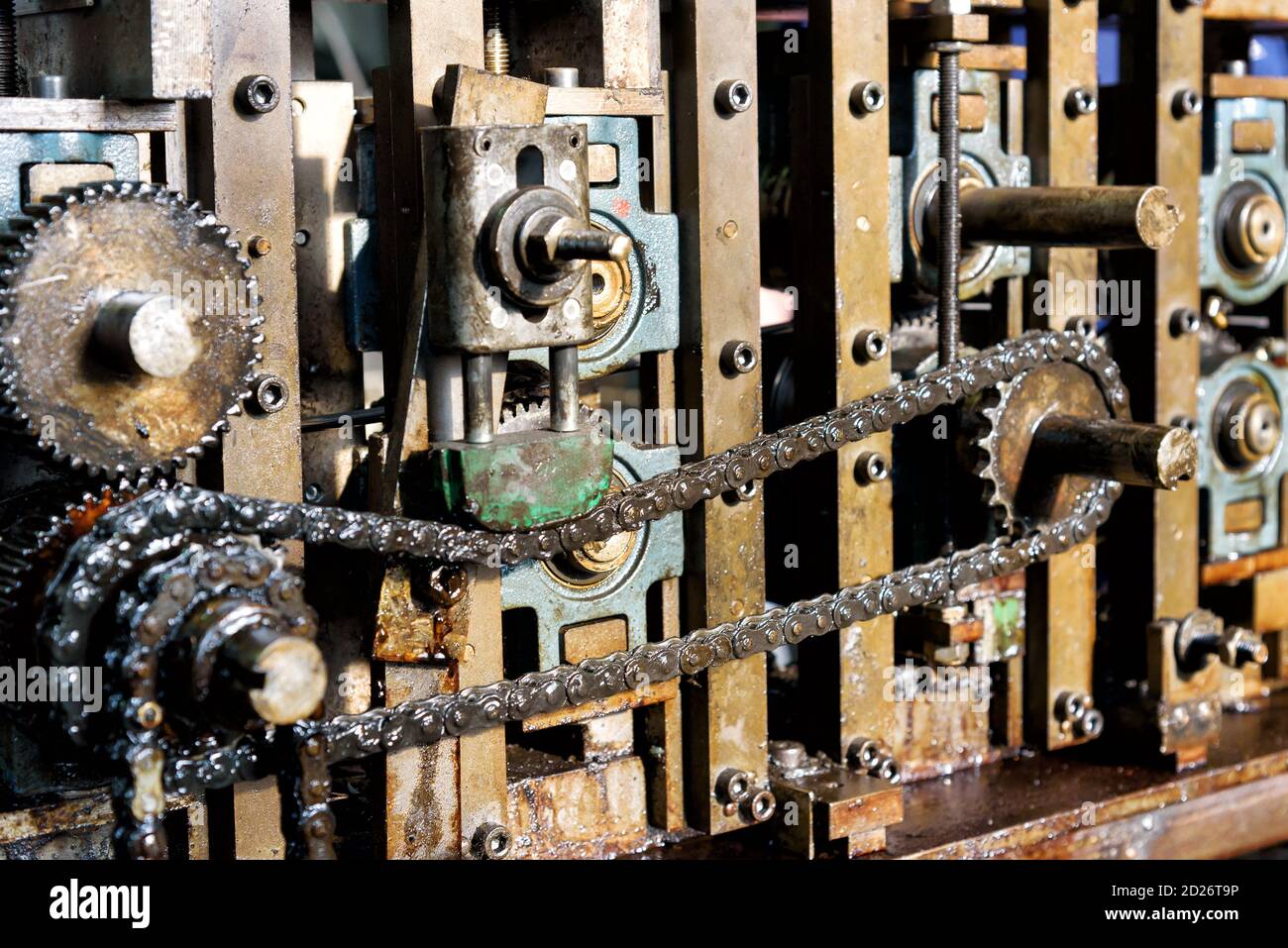 Primo piano sulla catena di trasmissione dei macchinari industriali che mostra la catena e gli ingranaggi per la trasmissione della potenza Foto Stock