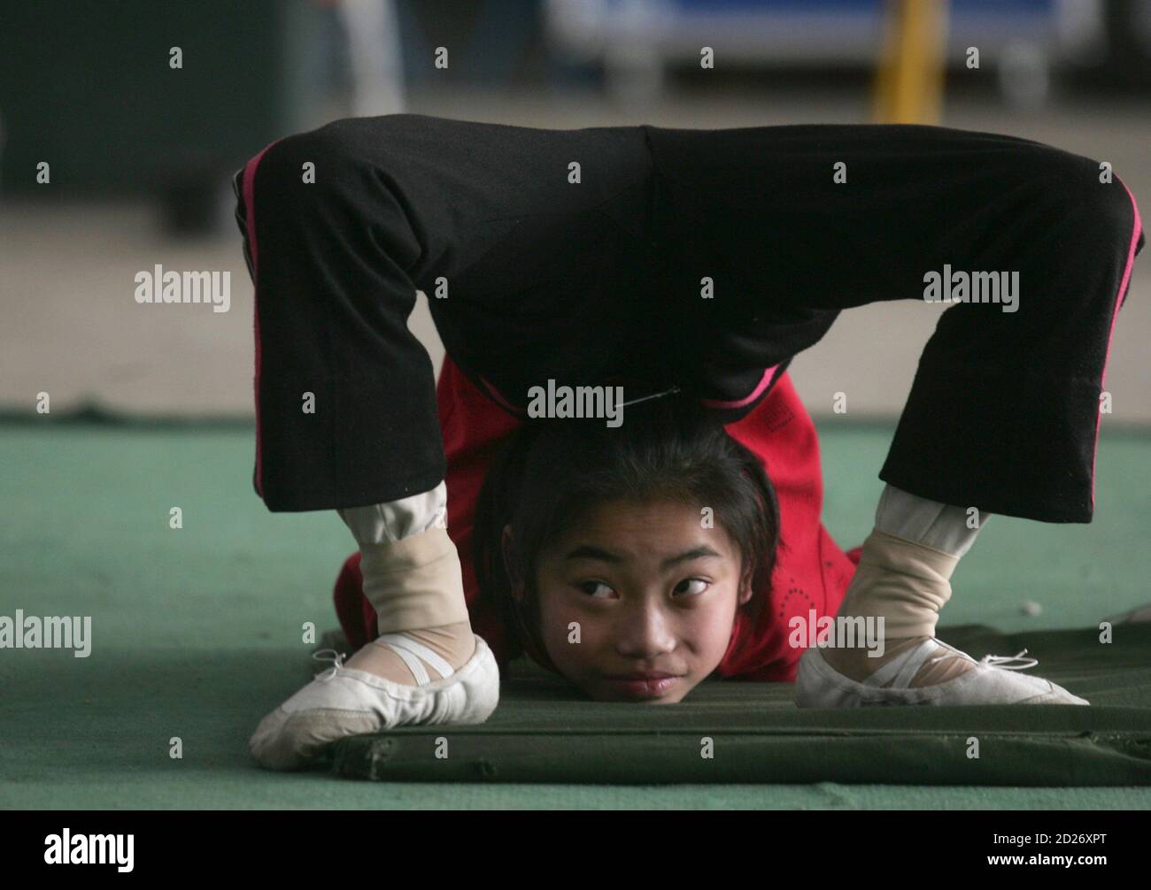 Un giovane contorsionista pratica durante una sessione di formazione in una scuola locale di acrobazie a Zhengzhou, provincia di Henan 24 aprile 2009. Circa 20 studenti, di età compresa tra 5 e 15 anni, ricevono una formazione presso la scuola che spera di esibirsi sul palco dopo 3 o 4 anni di pratica per fare un vivo, i media locali riportati. Foto scattata il 24 aprile 2009. REUTERS/Eric Zhao (SOCIETÀ DELL'EDUCAZIONE CINESE SPORT) Foto Stock