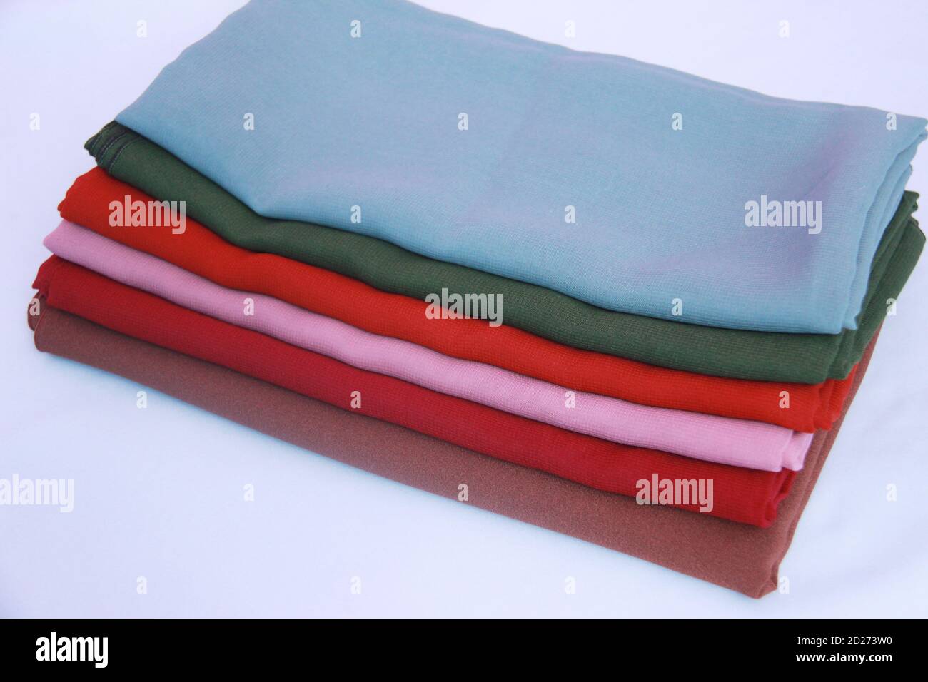 mucchio di veli colorati su sfondo bianco isolato. tessuto colorato con spazi di copia per mock up di vendita, testo, negozi, social media o altro ancora Foto Stock