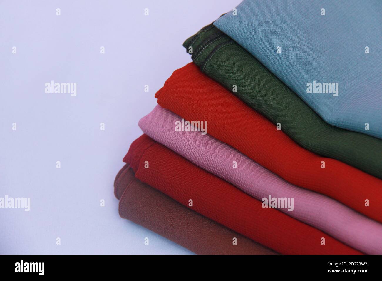 mucchio di veli colorati su sfondo bianco isolato. tessuto colorato con spazi di copia per mock up di vendita, testo, negozi, social media o altro ancora Foto Stock