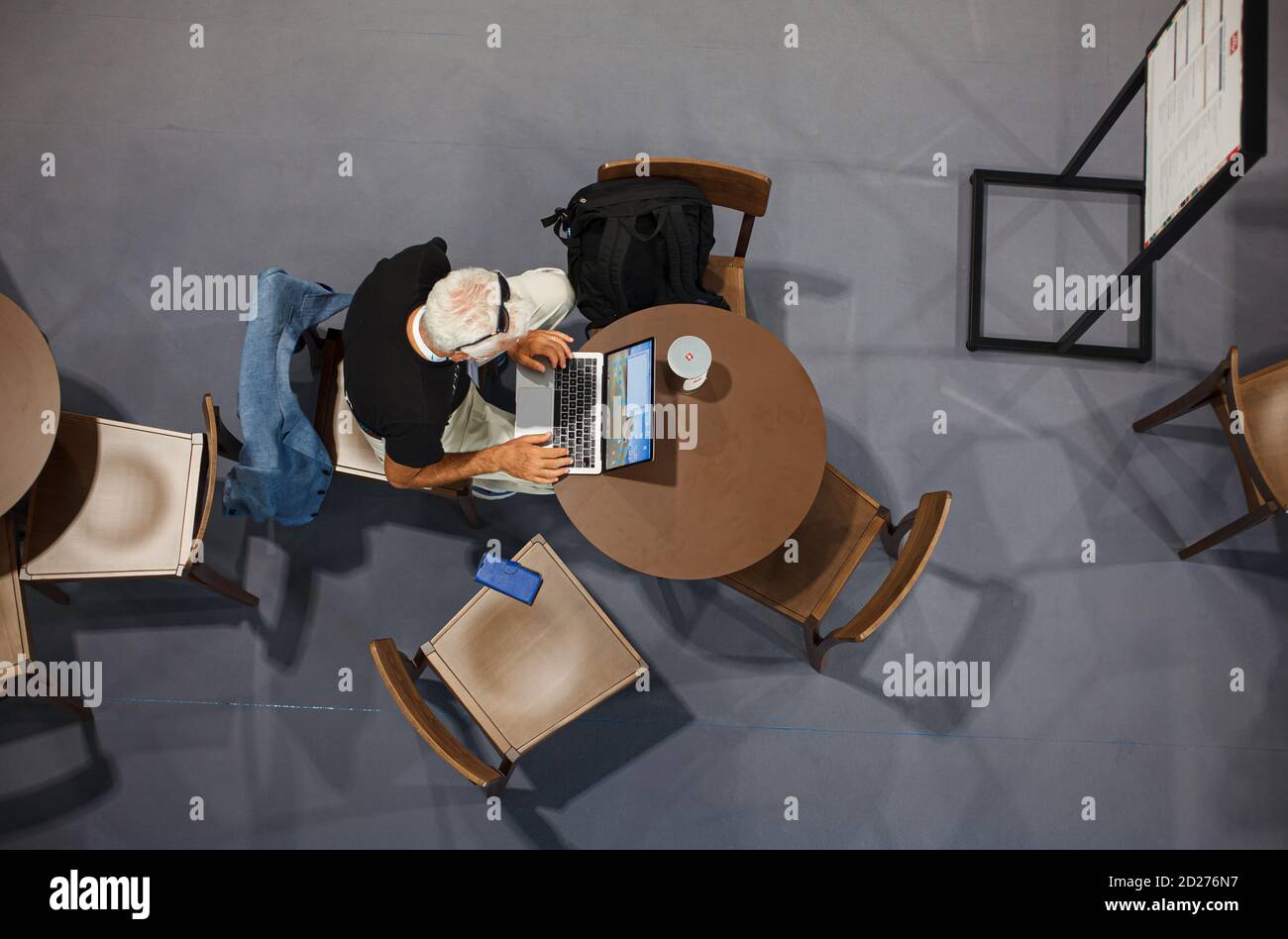 Trieste, Italia - Settembre, 06: Vista dall'alto di un uomo seduto al tavolo che lavora con il suo quaderno nella sala stampa durante l'ESOF, forum aperto di Euroscience Foto Stock