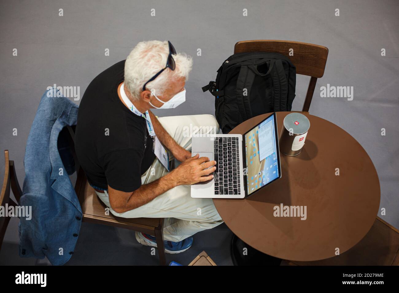 Trieste, Italia - Settembre, 06: Vista dall'alto di un uomo seduto al tavolo che lavora con il suo quaderno nella sala stampa durante l'ESOF, forum aperto di Euroscience Foto Stock