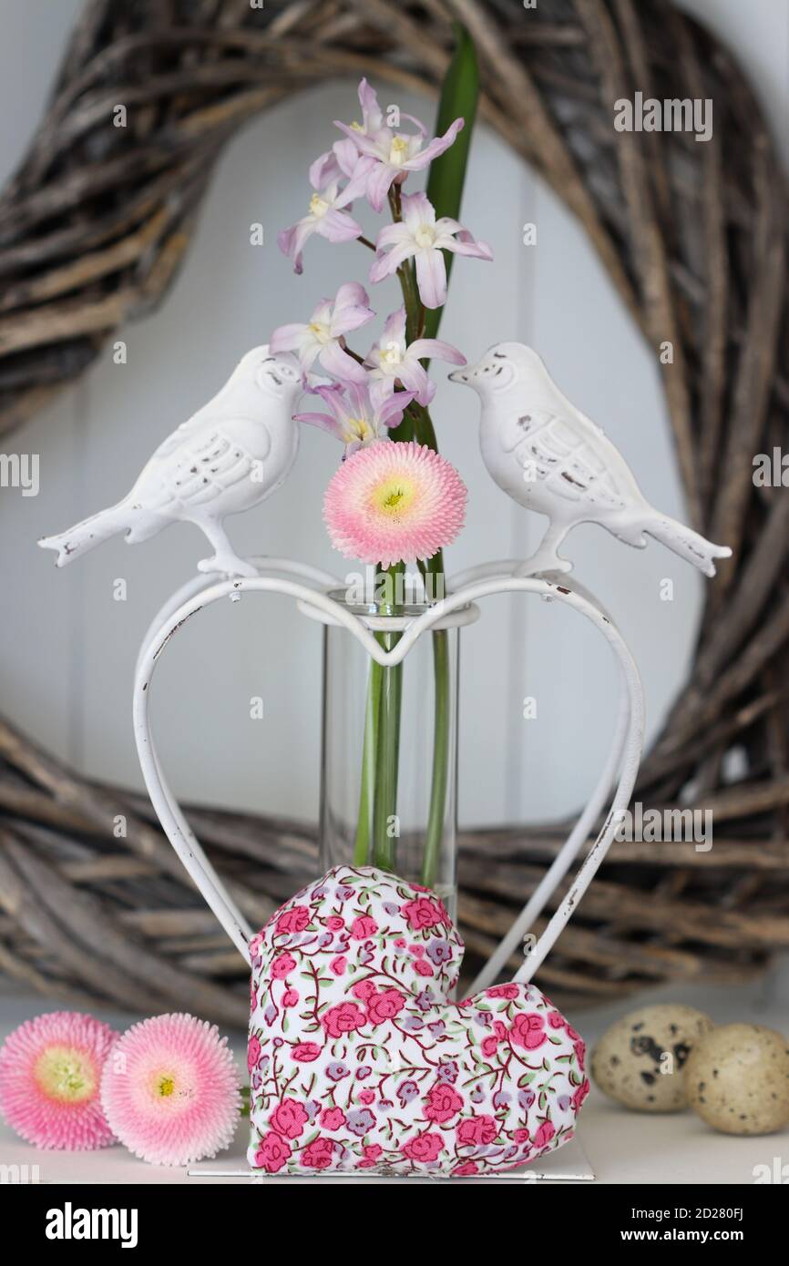 romantica decorazione primaverile con perennis di bellis rosa e cuore di tessuto Foto Stock