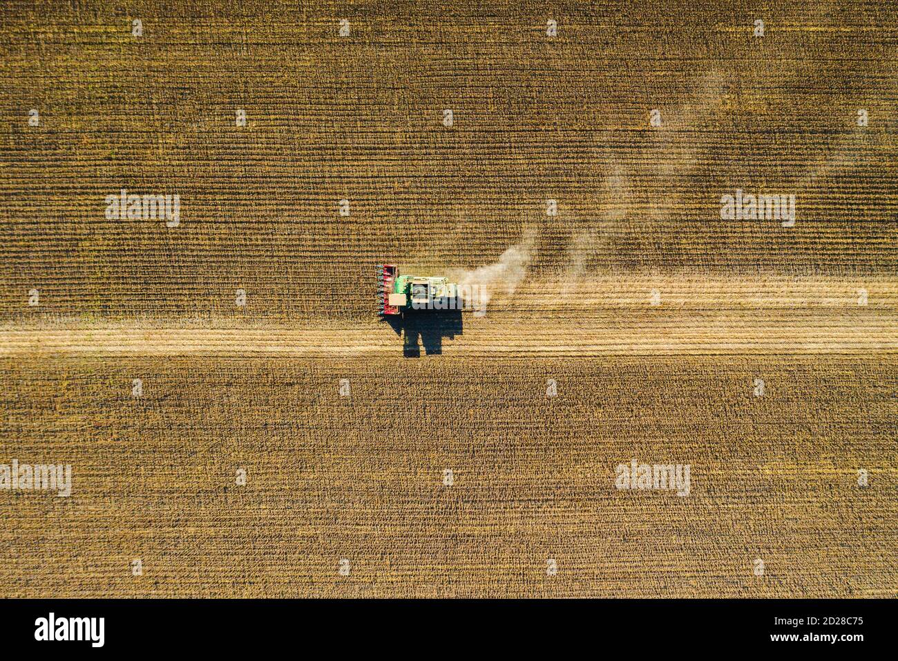 Vista aerea del drone con splendido paesaggio autunnale del trattore in funzione sul campo di raccolta. Concetto di agricoltura. Foto di alta qualità Foto Stock