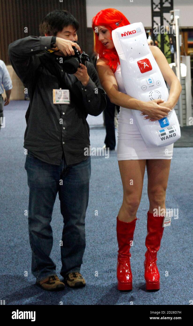 A visitor shows a photo on the back of a camera to a hostess from the Nyko Technologies booth as they talk during the Electronic Entertainment Expo or E3 in Los Angeles, June 3, 2009. The convention runs June 2-4. REUTERS/Danny Moloshok (UNITED STATES SCI TECH BUSINESS SOCIETY) Foto Stock