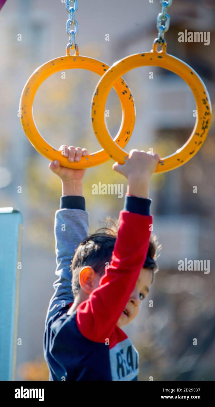 Sliven, Bulgaria - 4 novembre 2018: Bambino appeso su anelli su un parco giochi Foto Stock