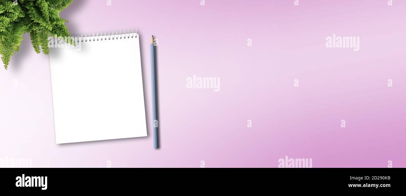 blocco note a spirale e matita vuoti per prendere appunti in rosa sfondo della scrivania Foto Stock