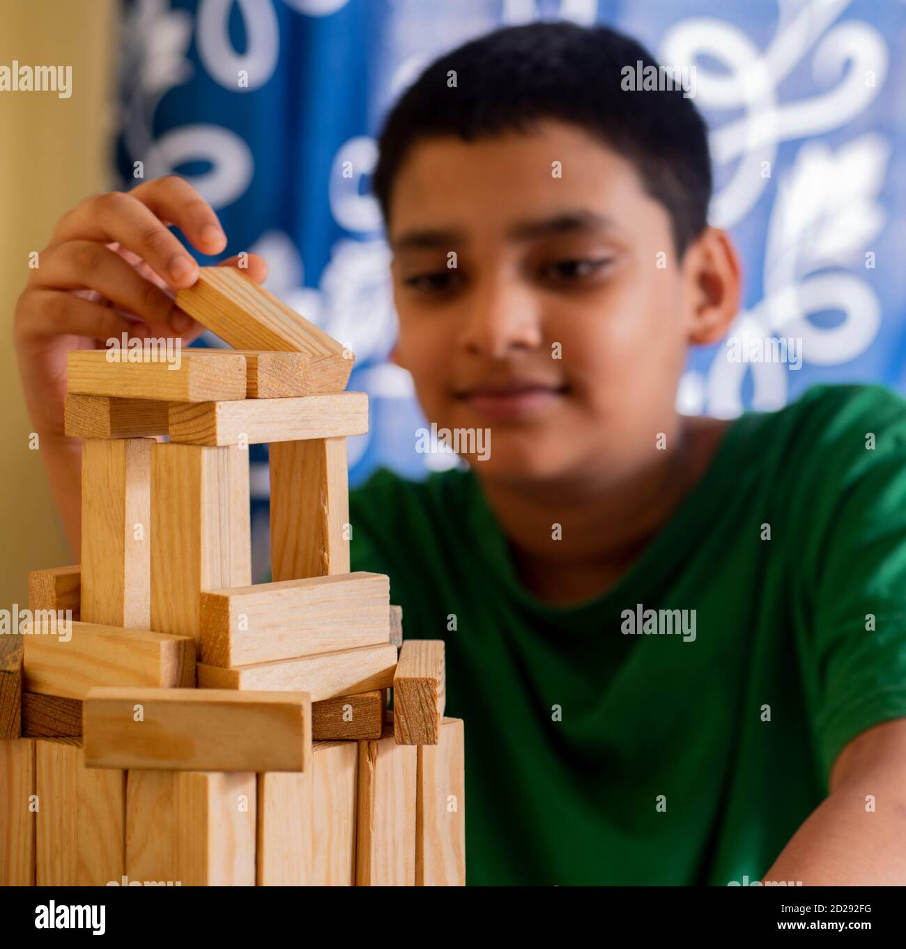 Ragazzo giovane godendo di costruzione castello da blocchi di legno Foto Stock