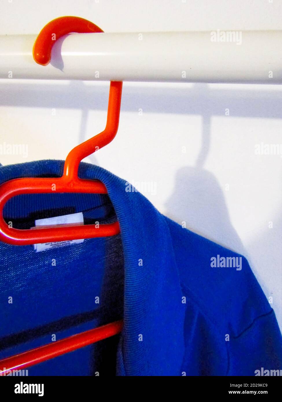 Camicia blu casual sull'appendiabiti rosso Foto Stock