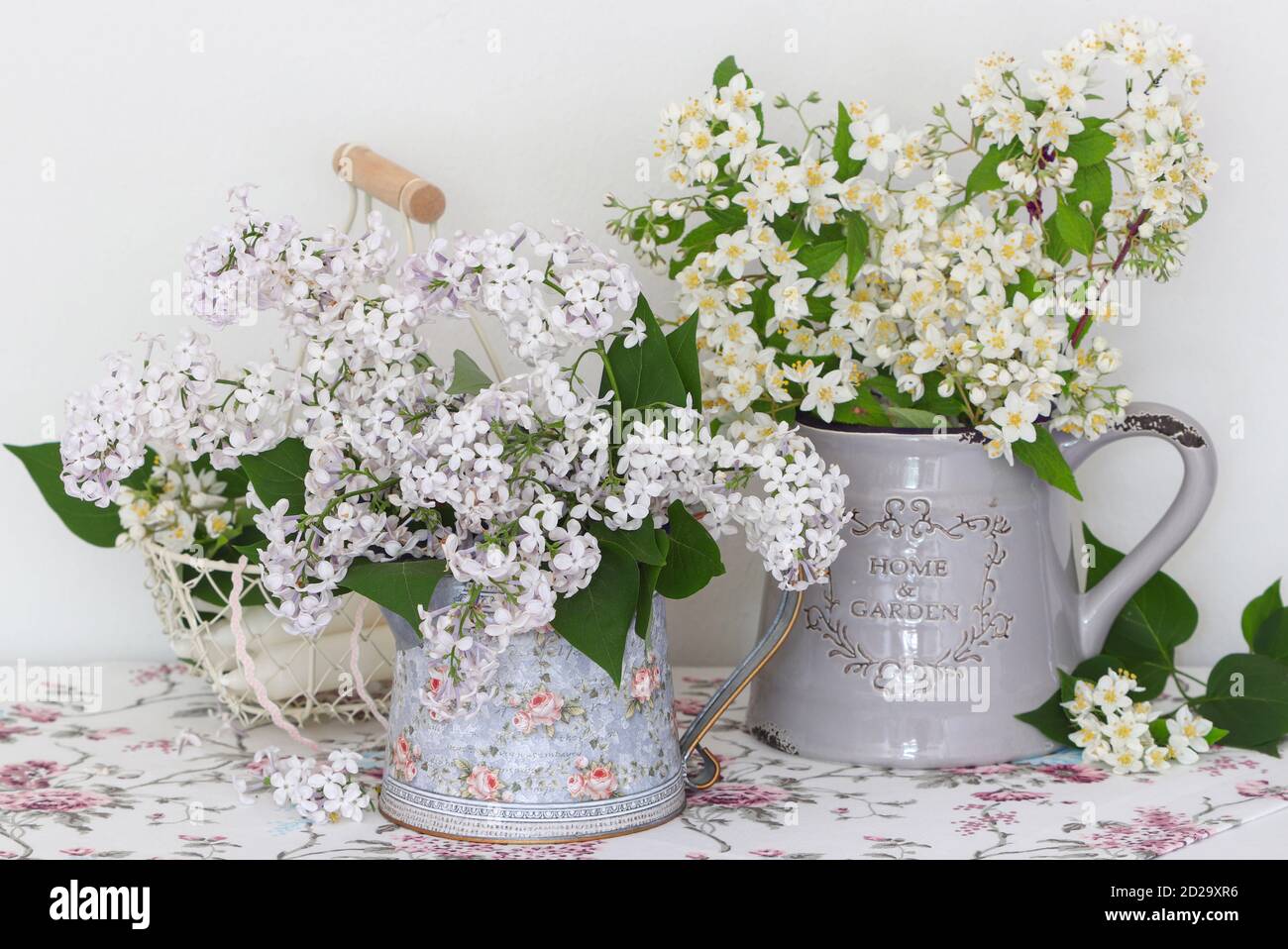 bouquet di fiori lilla bianchi e fiori di cespuglio di perle dentro vaso d'epoca Foto Stock