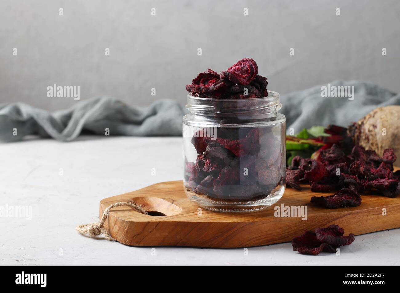 Scaglie di barbabietole in vaso di vetro e tavola di legno su sfondo chiaro. Spazio di copia. Foto Stock Scaglie di barbabietole in vaso di vetro e tavola di legno su sfondo chiaro. Spazio di copia. Foto Stock