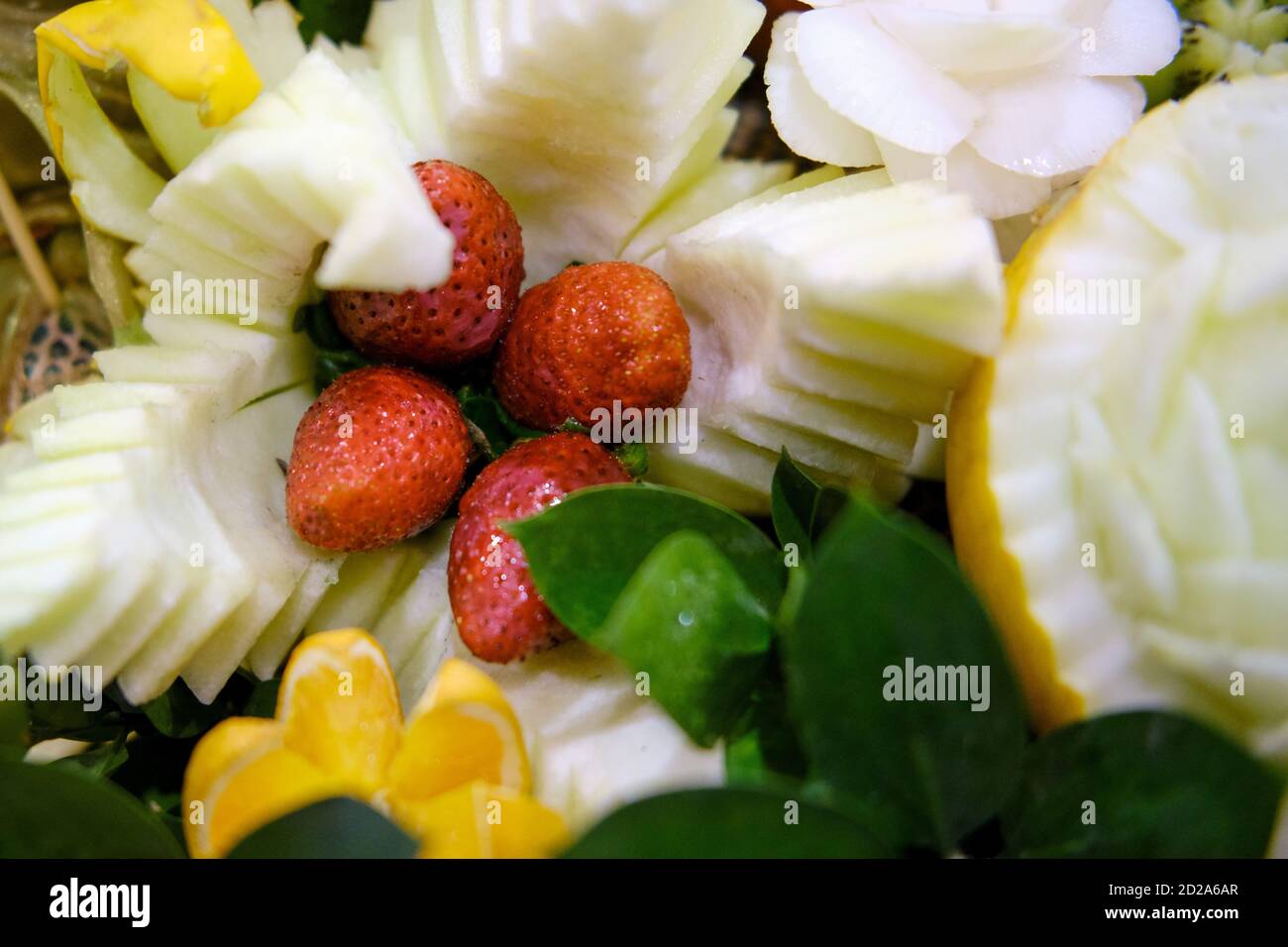 Intagliatura con verdure e frutta-fragole e melone in forma di fiore sul tavolo delle vacanze. Foto Stock