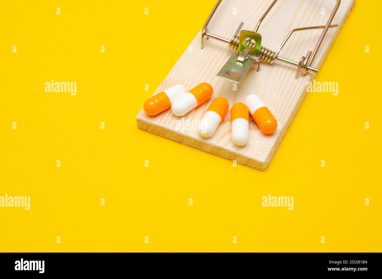 Mousetrap con pillole su sfondo giallo. Il concetto di salute, business Foto Stock