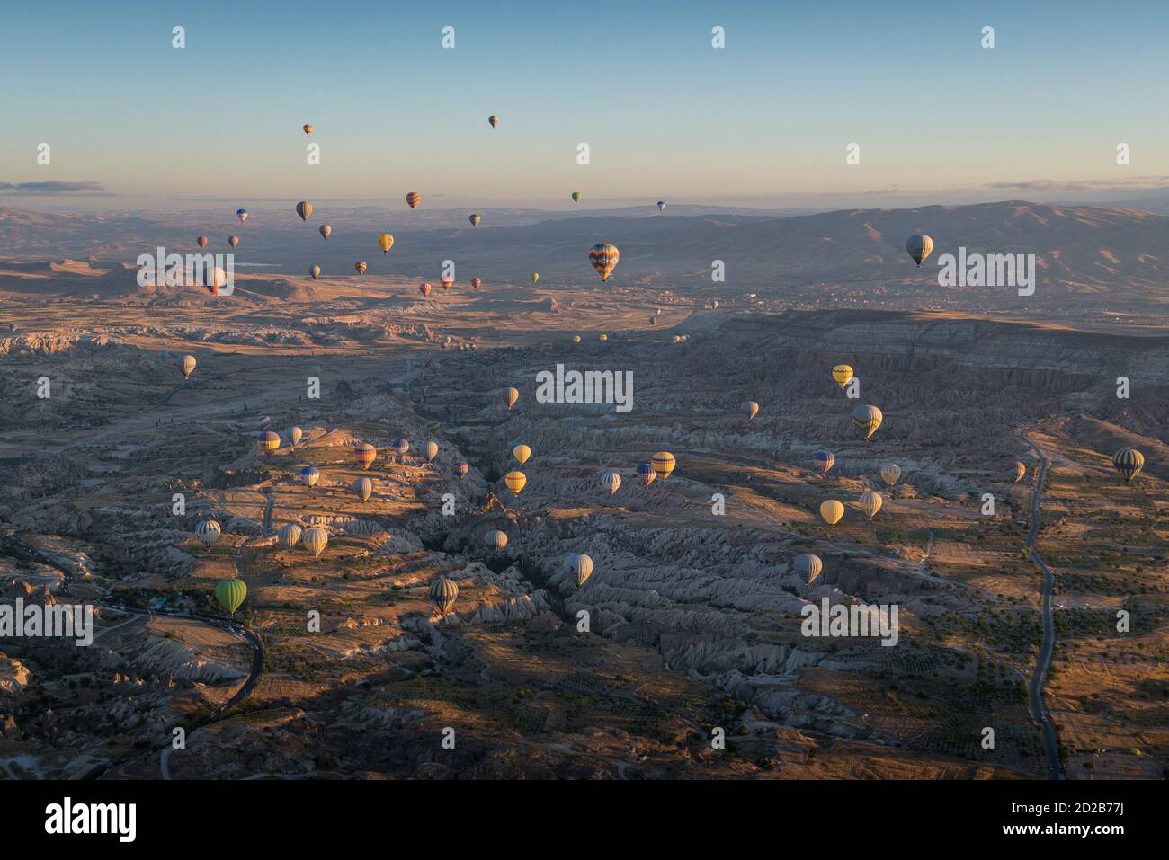Foto scenografica con baloni che sorvolano il paesaggio della Cappadocia alba Foto Stock