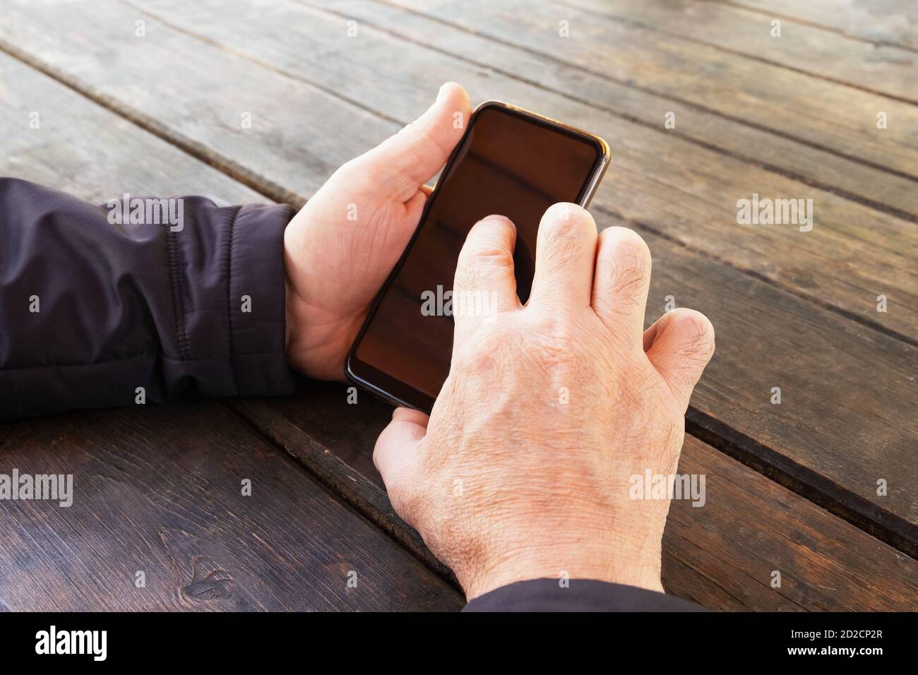 Le mani degli uomini tengono uno smartphone Foto Stock