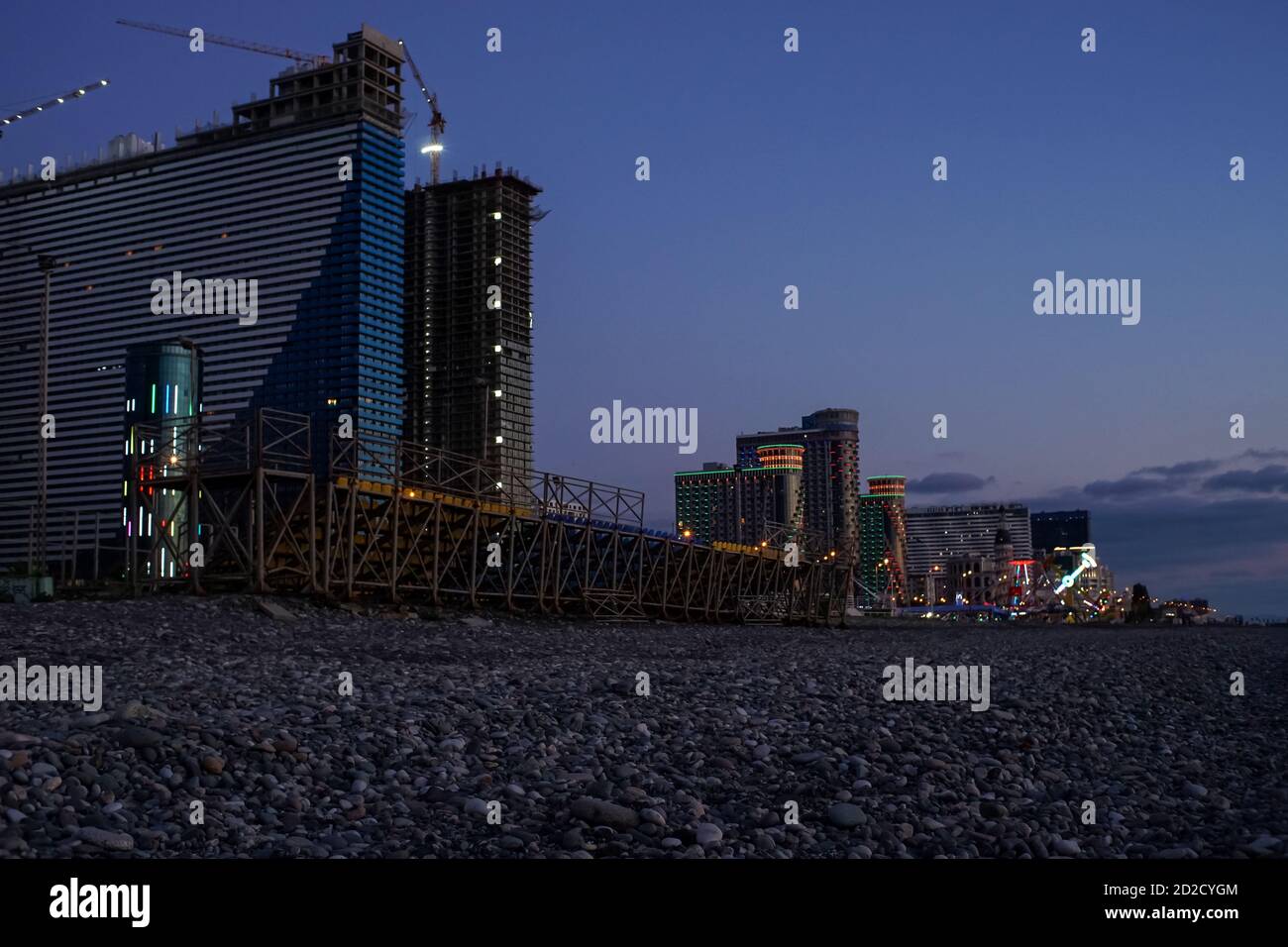 Wohnhochhäuser und Hotels an der Schwarzmeerküste bei Nachtbeleuchtung. Belichtete Urlaubsstadt am Abend, Batumi, Georgia Foto Stock