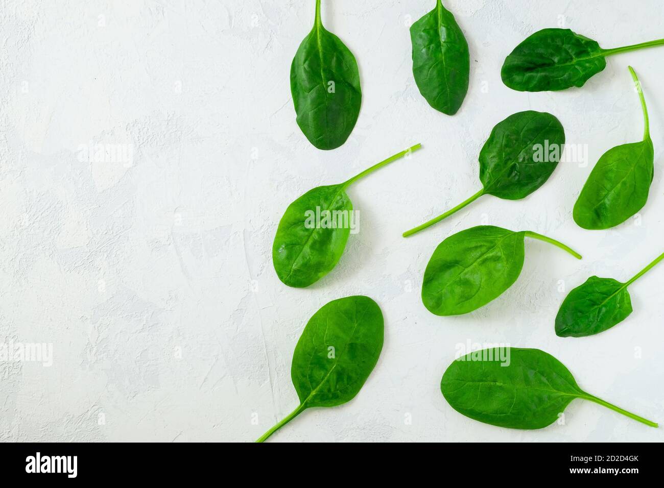 Foglie di spinaci fresche su una superficie leggera Foto Stock