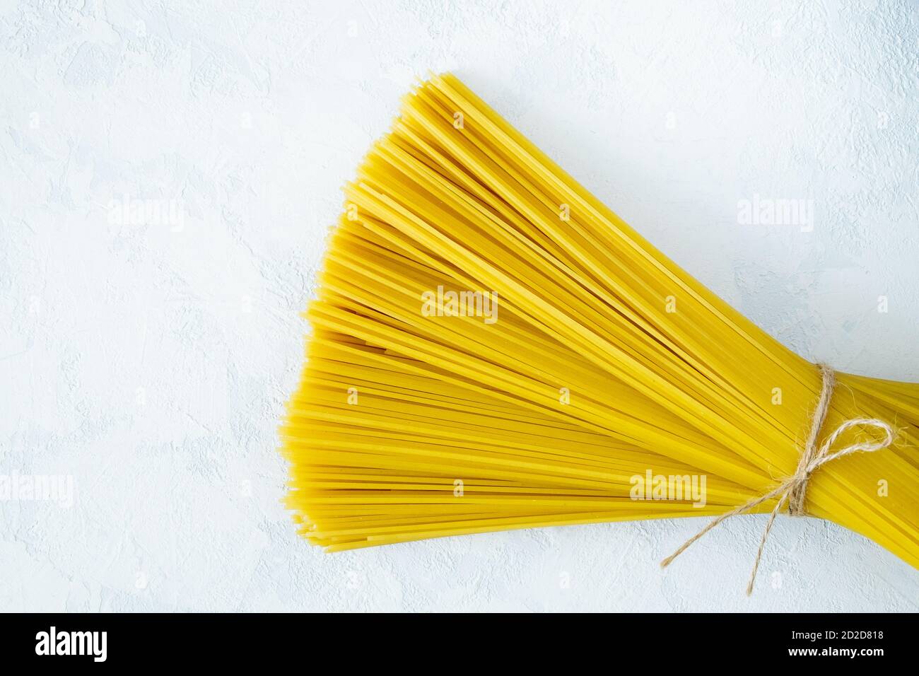 Un mazzo di spaghetti asciutti su uno sfondo chiaro Foto Stock