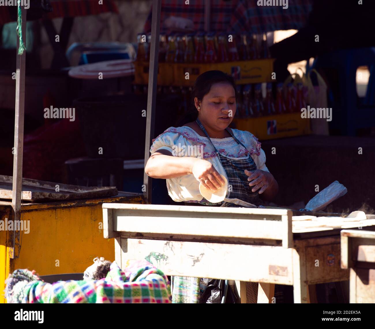 Una donna indigena Kiche Maya che fa e vende tortillas al mercato di Santa Cruz del Quiché, Guatemala. Foto Stock