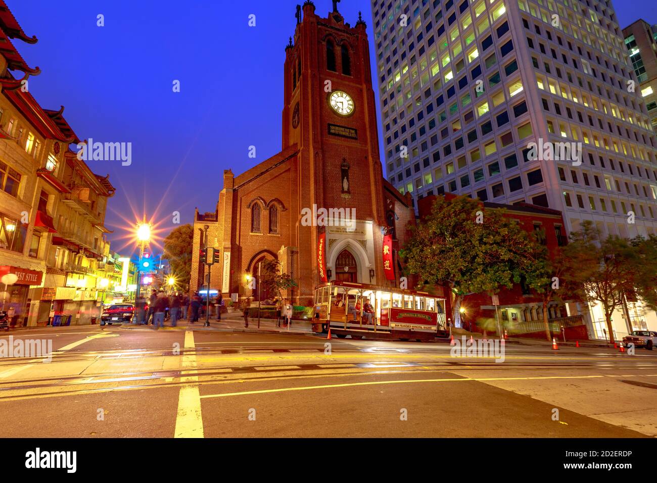 San Francisco, California, Stati Uniti - 15 agosto 2019: La funivia ferma di notte di fronte a una chiesa storica nel centro di San Francisco. Leggero Foto Stock