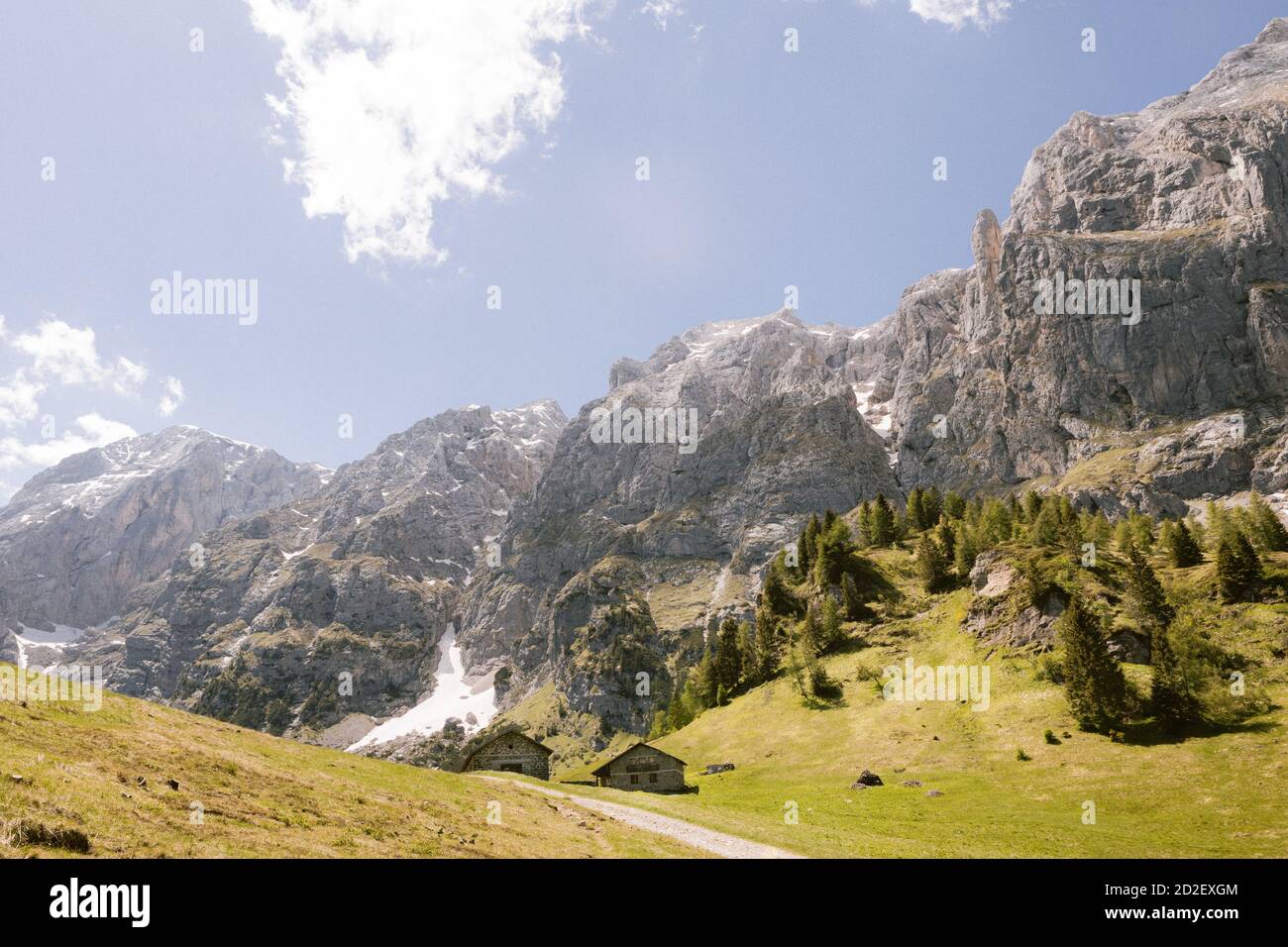 Strada per un rifugio isolato rifugio rifugio rifugio Rifugio Scarpa sulle Alpi italiane. Paesaggio delle Dolomiti, un prato verde e cielo nuvoloso sulla cima della montagna Foto Stock