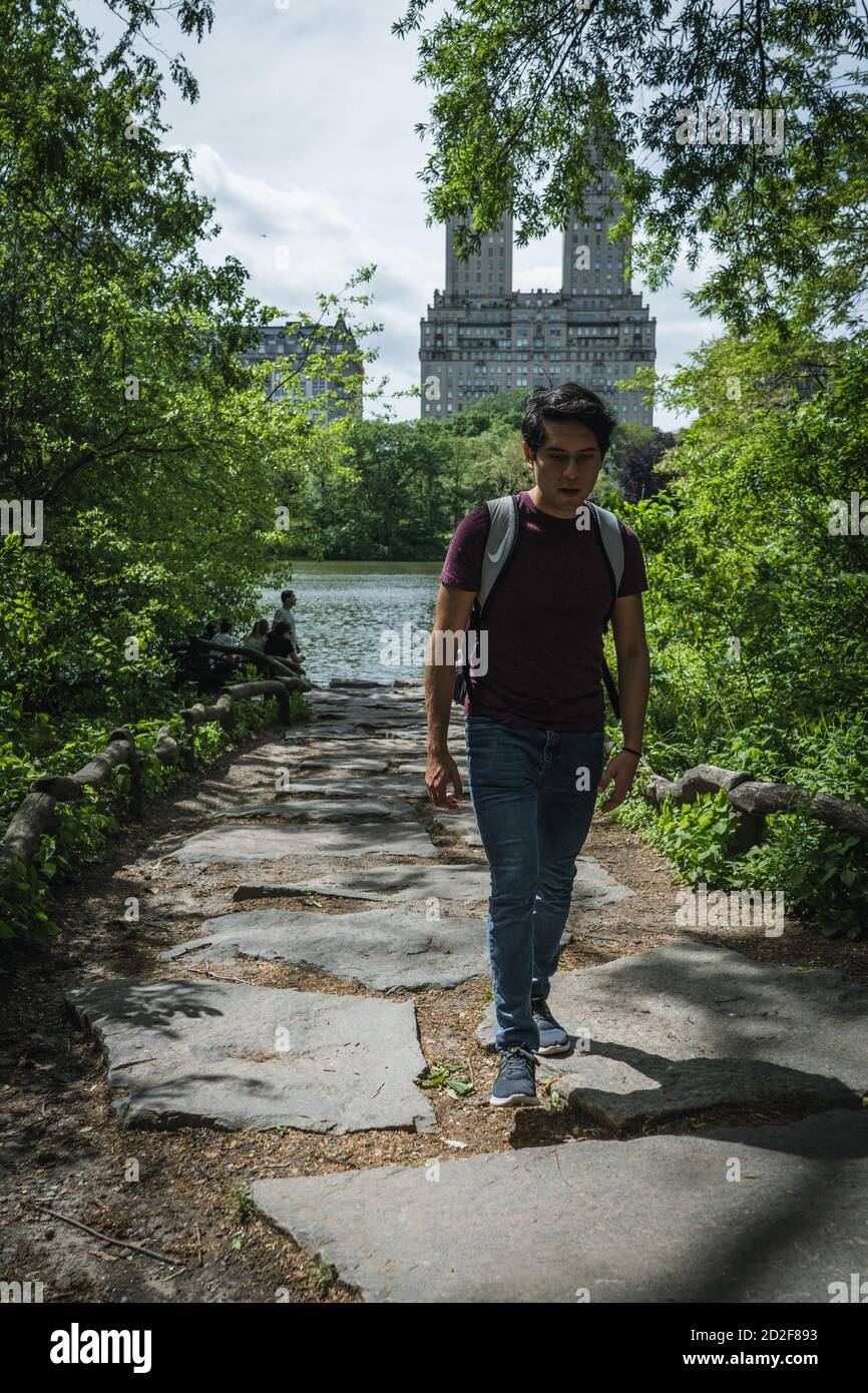 Giovane uomo che cammina nel parco centrale Foto Stock