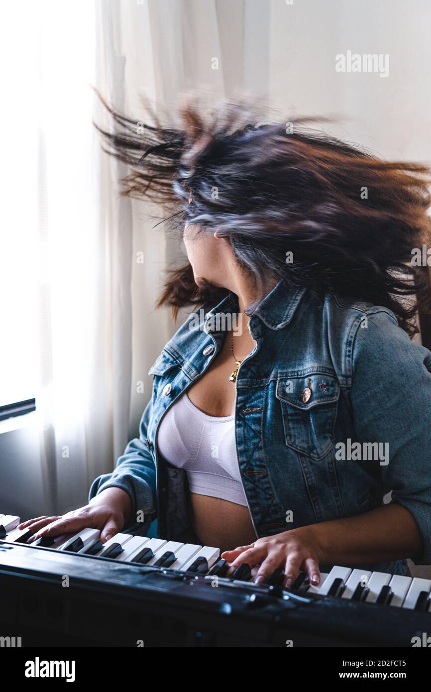 Ragazza che suona piano durante il blocco Foto Stock