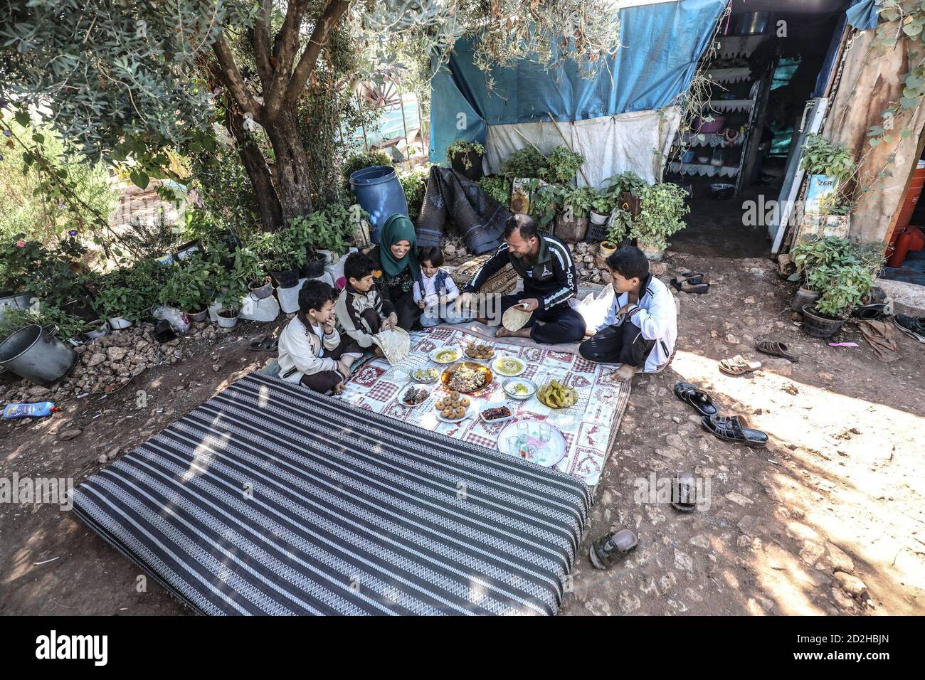 Idlib, Siria. 05 ottobre 2020. Una famiglia di Abu al-Walid (35) è vista in una tenda unica con un giardino lussureggiante e fiori, dove gli sfollati siriani si rifugiano in circostanze difficili a causa delle forze di regime di Assad e degli attacchi dei suoi alleati sulle aree residenziali, a Idlib, Siria, il 6 ottobre 2020. (Foto di Azalden Idlib/INA Photo Agency/Sipa USA) Credit: Sipa USA/Alamy Live News Foto Stock