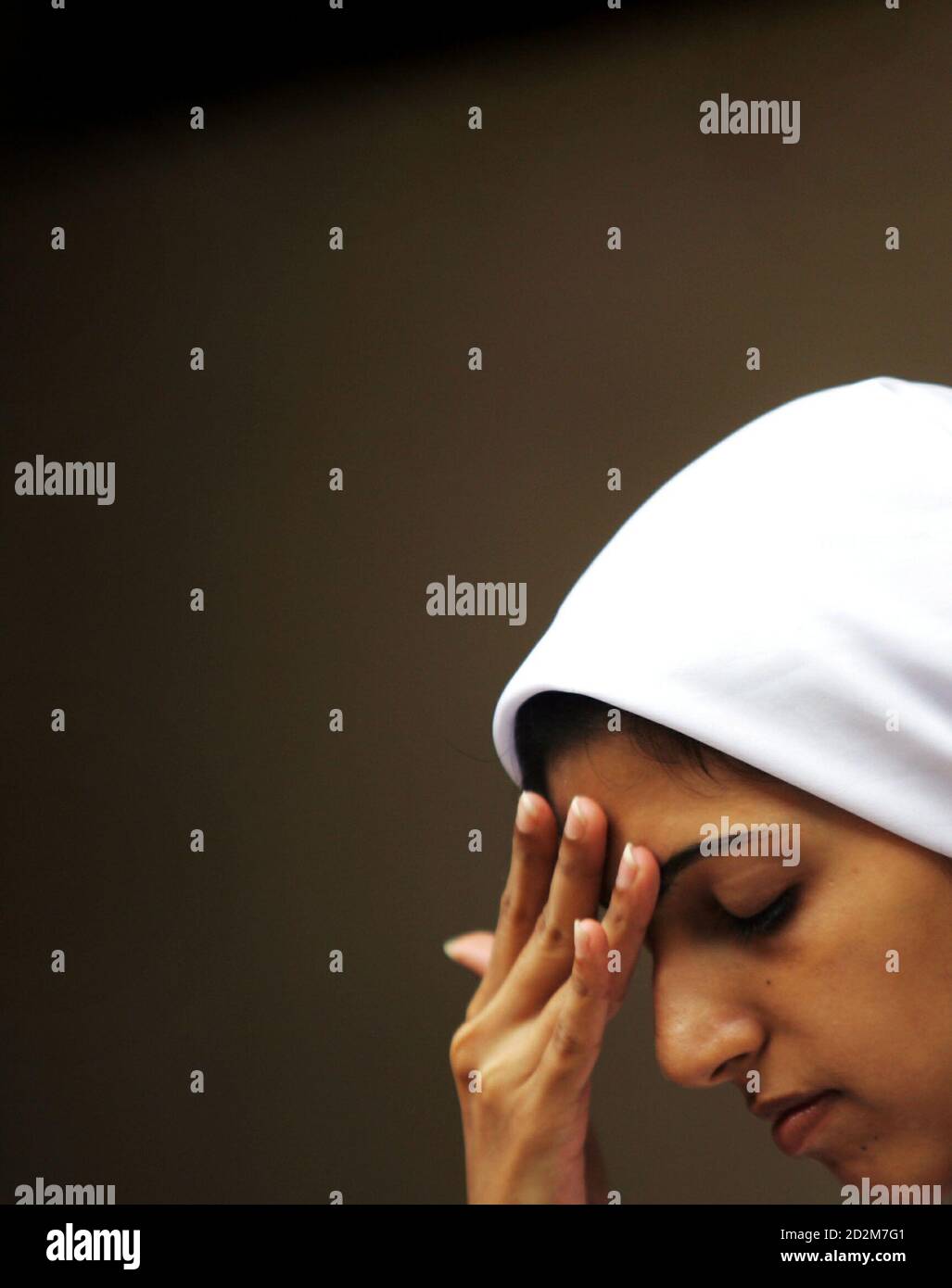 Una ragazza prega in un tempio di Parsi il nuovo anno di Parsi a Mumbai il 20 agosto 2005. Seguaci del profeta persiano Zarathustra, la comunità di Parsi arrivò nell'India occidentale 1200 anni fa dopo la fuga dalla Persia a seguito della persecuzione dei conquistatori arabi. Foto Stock