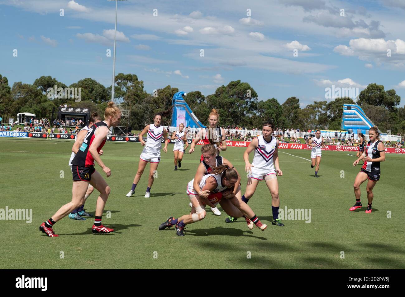Un giocatore viene affrontato durante una partita di calcio nella Football League australiana delle Donne. Foto Stock