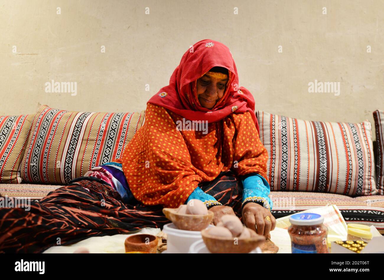 Una donna anziana Omani che lavora sull'artigianato in un centro storico del forte di Nizwa in Oman. Foto Stock