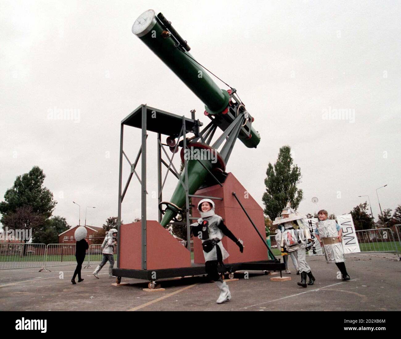 Gli studenti della scuola elementare St Michaels RC, assestati come pianeti e hardware spaziale, ballano intorno a una ricreazione del telescopio di William Lassell che è stato collocato sul posto nel parco giochi della scuola, che ha occupato 150 anni fa. L'originale fu utilizzato da William Lassell esattamente 150 anni fa per scoprire Triton, il più grande satellite del pianeta Nettuno. La scuola ora si trova sul sito della casa di Lassell in Guion Street. Vedi PA Story SCIENCE Telescopio/Pic Dave Kendall/PA. Foto Stock