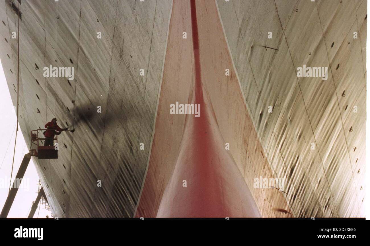 Uomo di lavoro riverniciare il QEII, il lavoro di riparazione sul famoso transatlantico sarà completato entro giovedì prossimo, quando è previsto di lasciare lo storico bacino secco di King George V a Southampton. Foto di Tim Ockenden Foto Stock