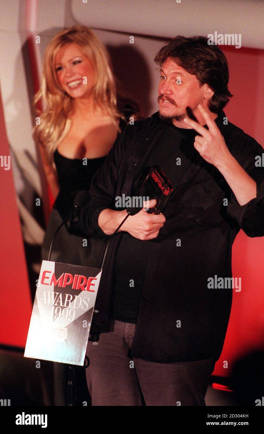 Peter Howitt, ex star del pane comico di BBC1, gesture all'Empire Film Awards di Londra, dopo che gli è stato consegnato il premio miglior regista britannico per la sua commedia romantica Sliding Doors, dal presentatore televisivo Melinda Messenger (L). Foto Stock