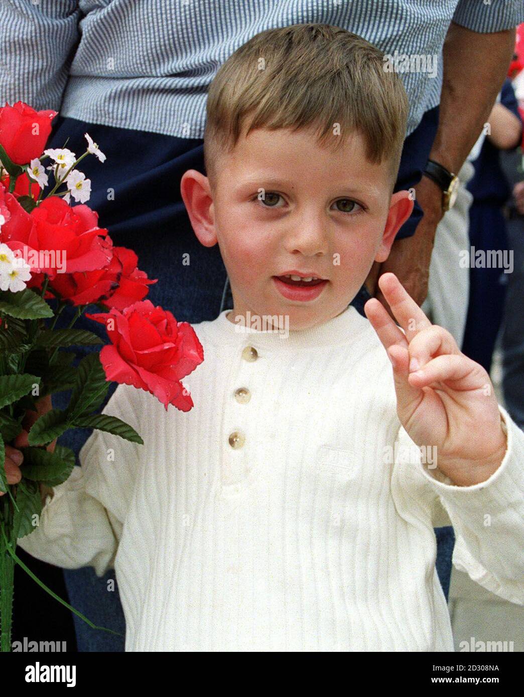 Un ragazzo fa un segno di pace fuori dal Palazzo di Westminster a Londra, mentre un grande gruppo di albanesi del Kosovo si riunì per ringraziare Tony Blair, il popolo britannico e la NATO per la liberazione del Kosovo. Foto Stock