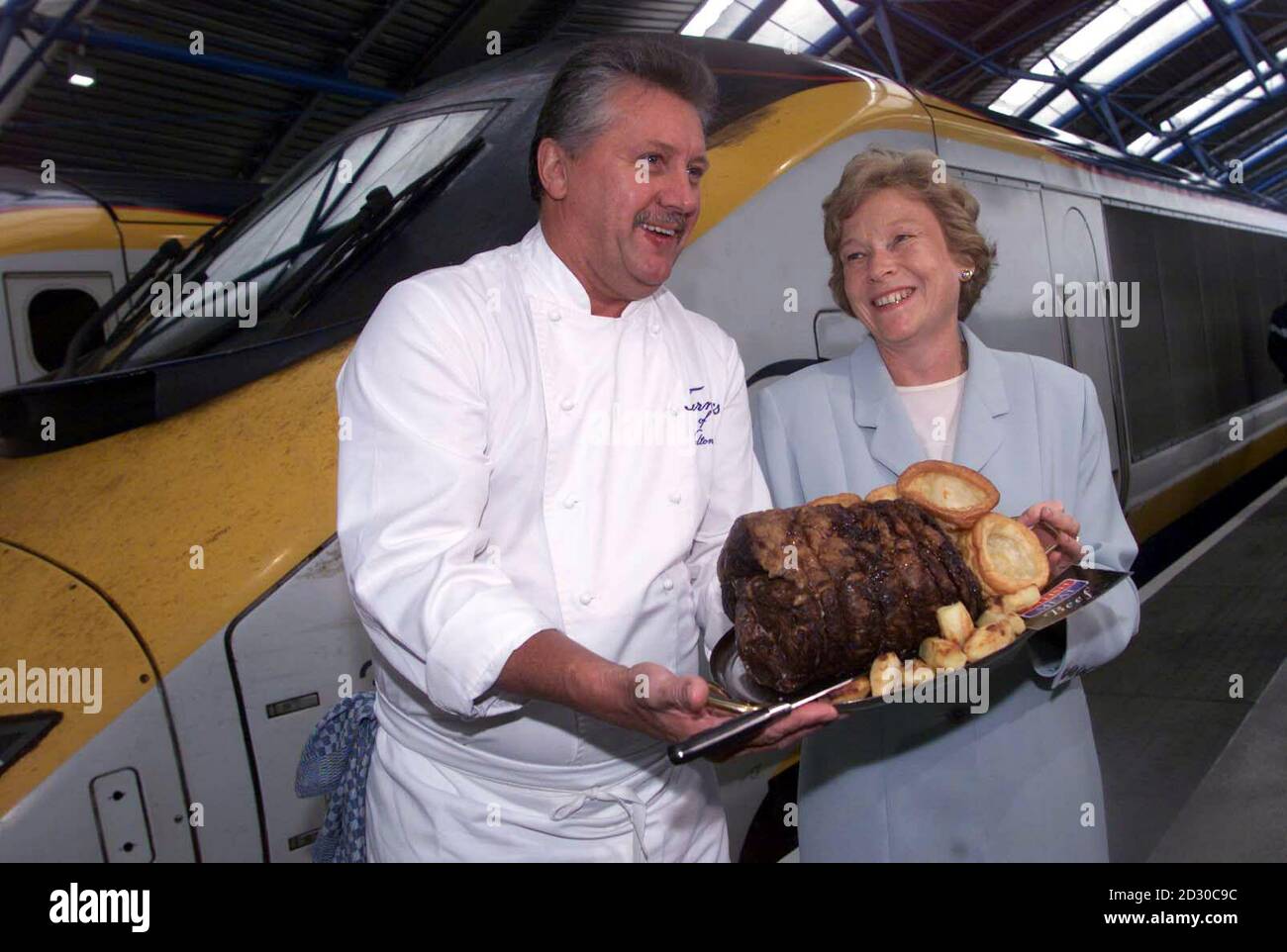 Lo chef Brian Turner con il vice ministro dell'Agricoltura Joyce Quin e un piatto di manzo britannico, prima di salire a bordo del treno Eurostar alla stazione di Waterloo. Le due costolette di manzo di prima qualità sono sulla via di un pranzo ospitato dalla Commissione per la carne e il bestiame a Bruxelles. Foto Stock