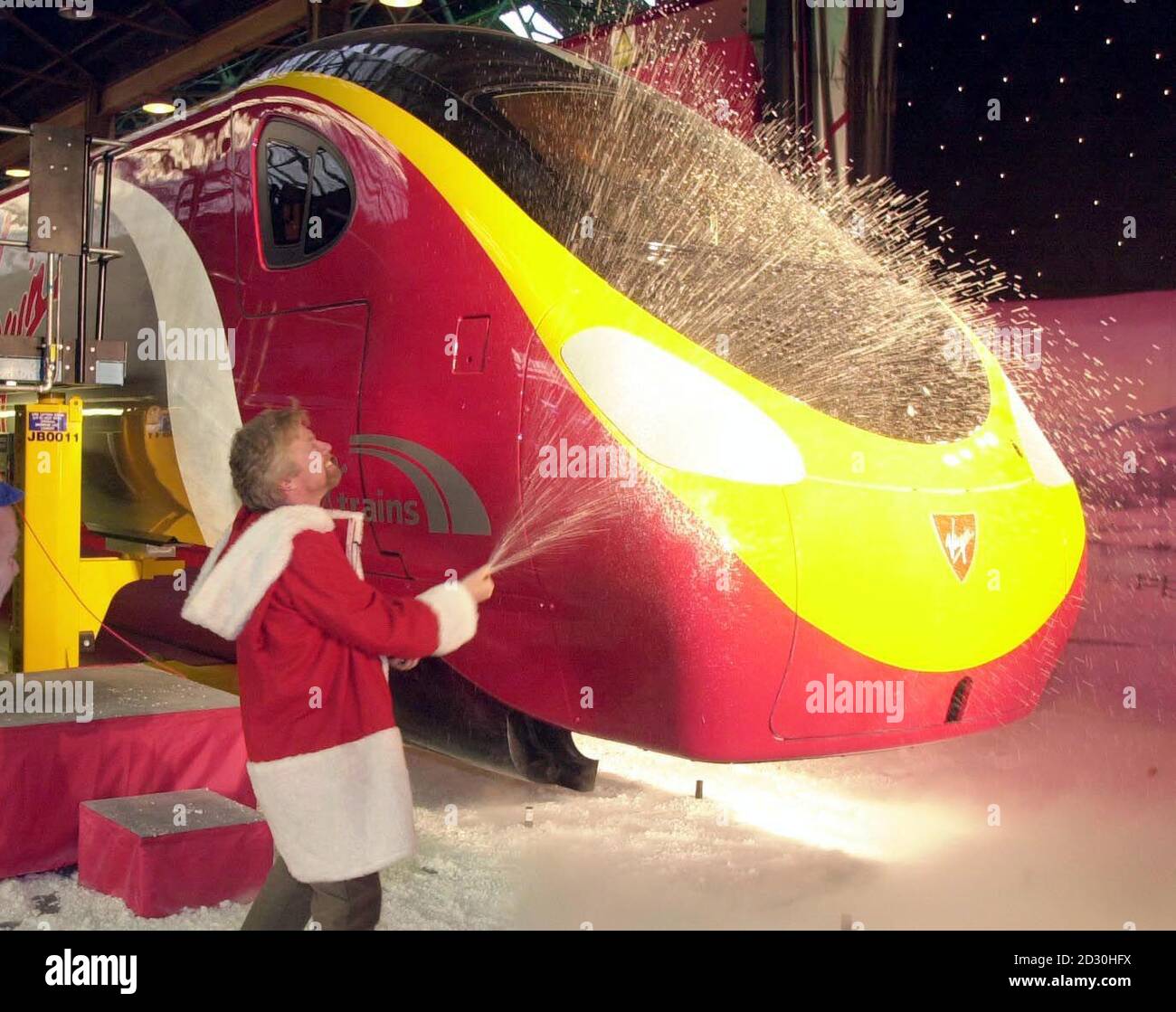 Richard Branson, capo del treno Virgin, vestito come Babbo Natale lancia il suo nuovo treno inclinabile ad Alstom a Washwood Heath, Birmingham, con uno spruzzo di champagne. L'azienda prevede di sostituire l'intero materiale rotabile della West Coast Mainline entro il 2002. * ...introducing nuovi treni a 140 miglia/h che riducono i tempi di percorrenza del 25% e consentono un maggiore servizio sulle rotte principali. Foto Stock