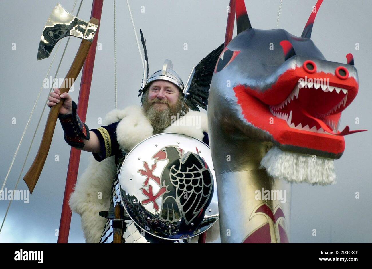 Un guizer della squadra Jarl di Shetlanders vestita come vikings saluta la folla da sulla cima della cucina, una longship di legno di 30 piedi a Lerwick, isole Shetland, come parte del tradizionale festival pagano di Up Helly AA. La cucina sarà bruciata dai guizzatori in una cerimonia. Foto Stock