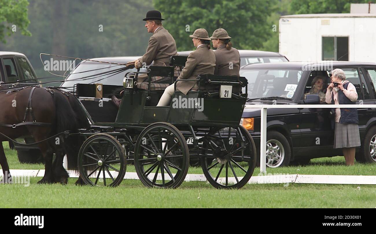 Britains Queen Elizabeth II (all'estrema destra) è distratta come suo marito, il Duca di Edimburgo passa al Royal Windsor Horse Show. Era in gara nella sezione dressage del Gran Premio di guida internazionale di Asprey & Garrard. Foto Stock