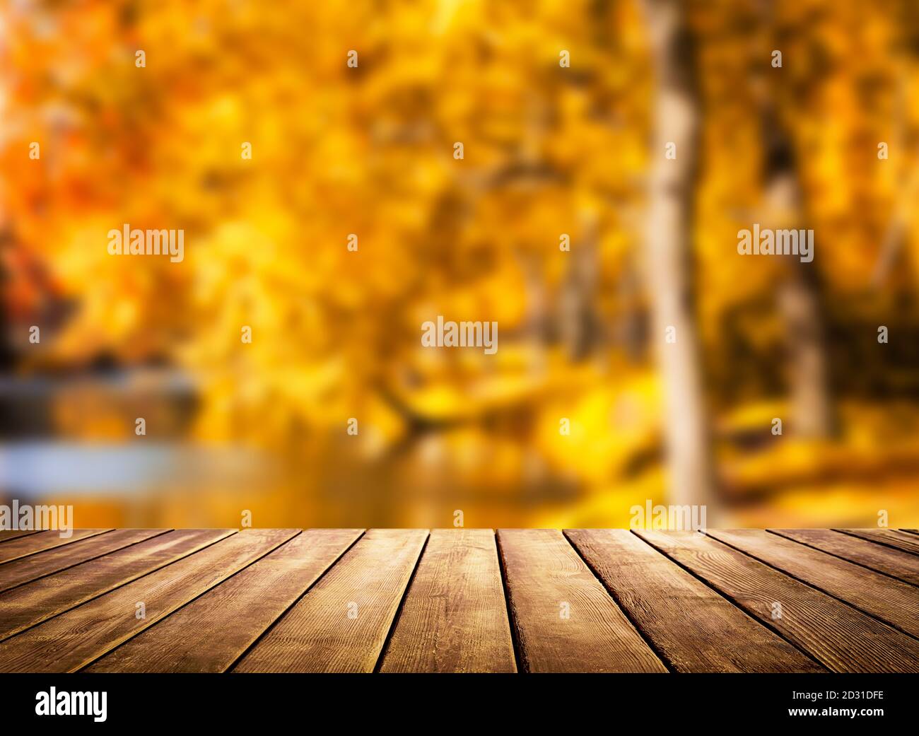Piano in legno su sfondo autunno sfocato. Autunno oro sfondo astratto con bokeh luce. Foto Stock