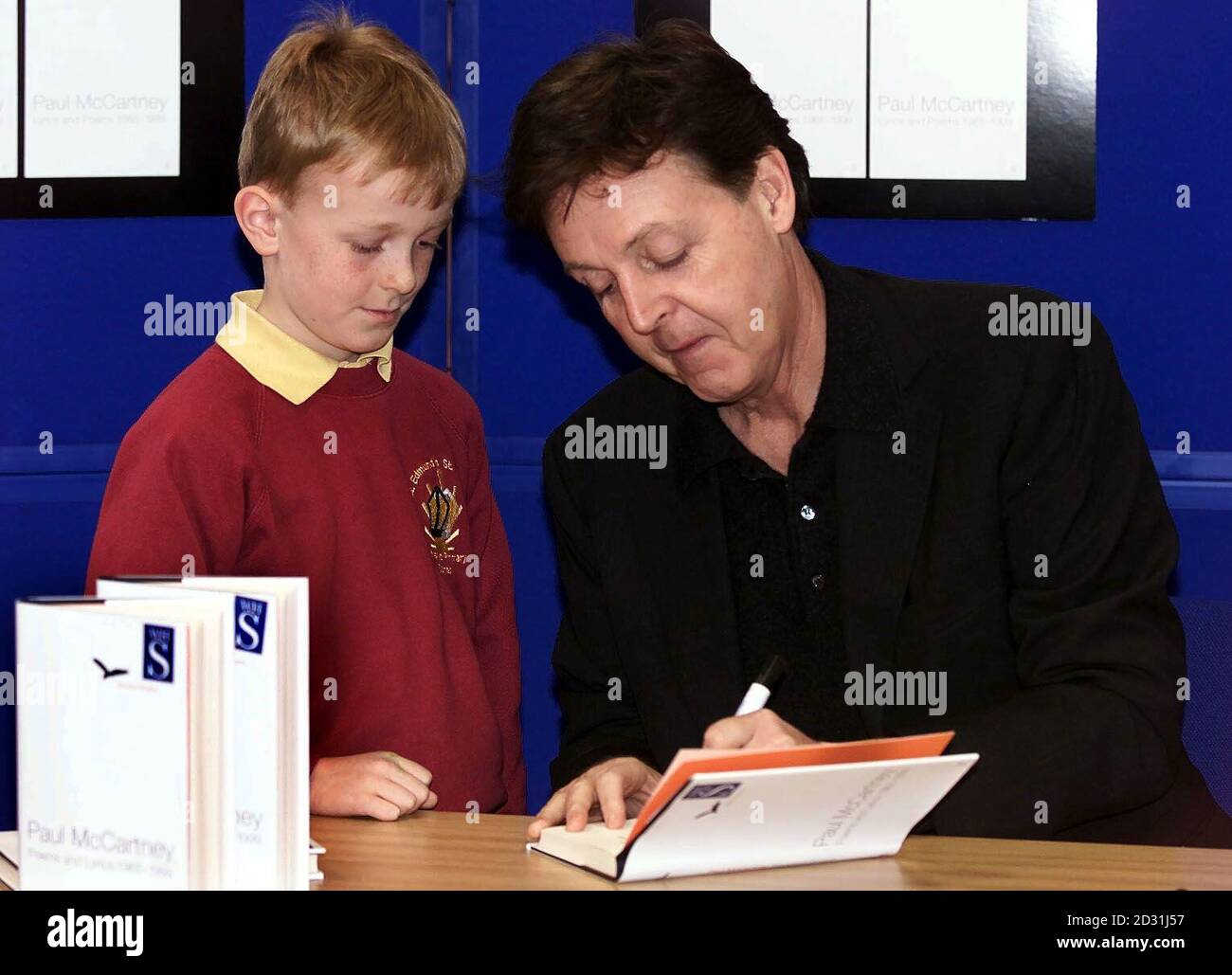 Charlie McKeown, di otto anni, di Waterloo, con l'ex Beatle Sir Paul McCartney durante un libro firmato a Liverpool, il 21 marzo 2001. *come una folla di più di 1,000 persone si riunì fuori da WH Smiths in Church Street, Sir Paul fu portato nel negozio attraverso una porta posteriore prima di prendere posto per firmare circa 500 copie dell'antologia Blackbird Singing. Foto Stock