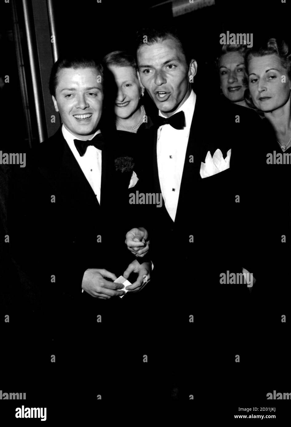1950: Mentre la star del cinema britannico Richard Attendborough (l) sembra divertita, Frank Sinatra, il cricchiolio americano, sembra nel mezzo di uno di quei suoi devastanti numeri. L'occasione è la prima notte del musical di Noel Coward 'Ace of Clubs' al Cambridge Theatre di Londra. Foto Stock