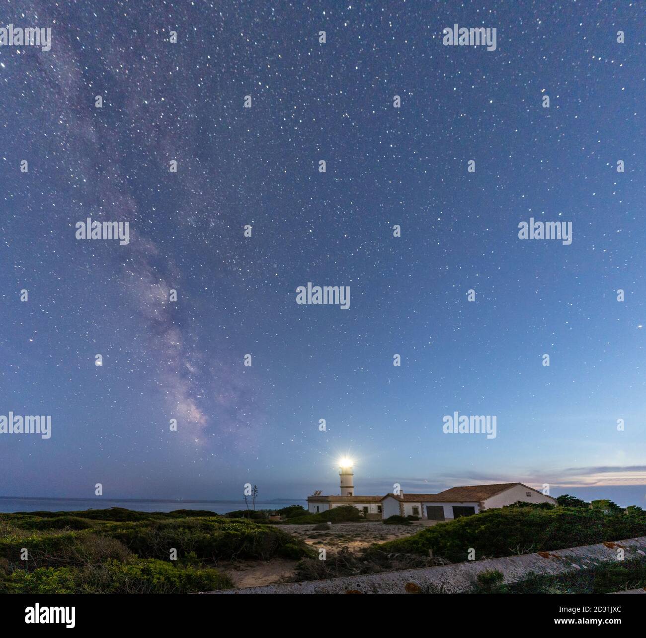 Via Lattea sopra il faro di Ses Salines, Maiorca in una notte stellata Foto Stock