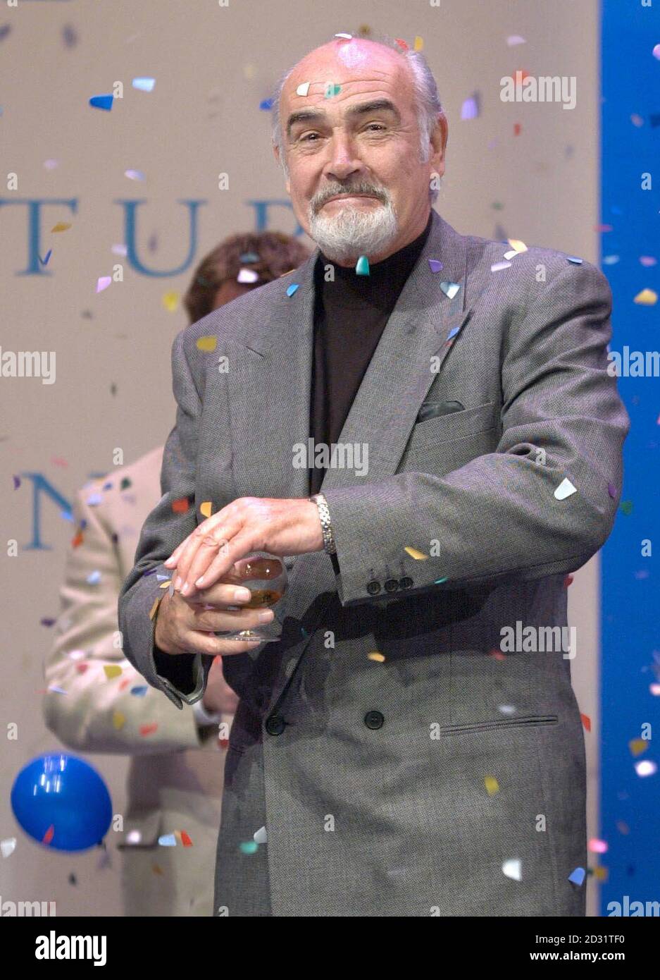 Sir Sean Connery scudi il suo bicchiere di whisky dai confetti alla riapertura del Teatro Byre a St Andrews, Fife. Connery, che è diventato presidente onorario del teatro due anni fa, è stato ospite d'onore alla cerimonia per la sua riapertura dopo una ristrutturazione di 5.7 milioni di euro. *originariamente una capanna dove il pubblico sedeva su cuscini sparsi sul pavimento, è stato ridisegnato come il primo teatro della Scozia per il millennio. Foto Stock