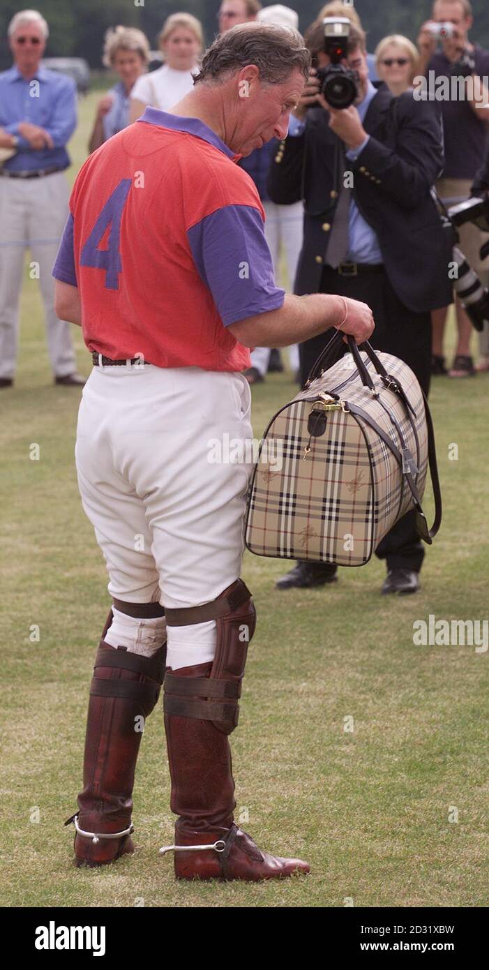 Il Principe del Galles riceve i bagagli di Burberry dopo il suo lato del Polo Club di Highgrove in cui il figlio più giovane del Principe Carlo Harry stava giocando perso a Cirencester 6:3 in una partita di quattro chukka al Cirencester Park Polo Club, Cirencester, Gloucestershire. Foto Stock