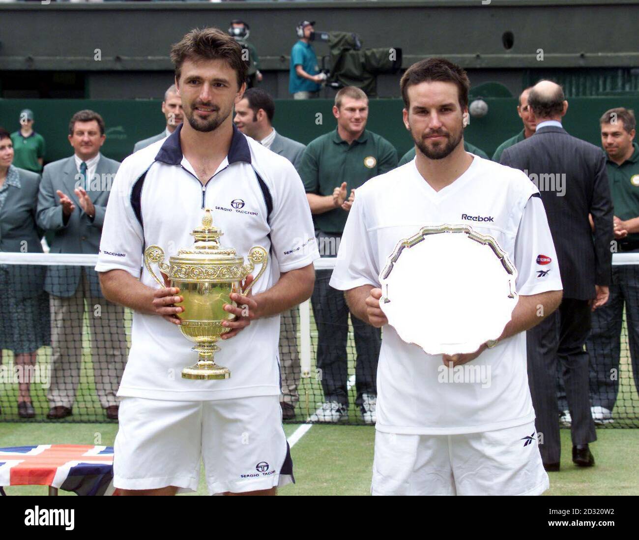 NESSUN USO COMMERCIALE: Goran Ivanisevic della Croazia (a sinistra) festeggia con il trofeo dopo aver battuto il Pat Rafter australiano durante la finale di Mens dei Campionati di tennis al prato 2001 a Wimbledon a Londra. Ivanisevic ha vinto 6-3, 3-6, 6-3, 2-6, 9-7 . Foto Stock