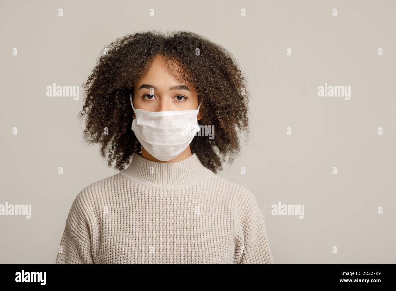 Protezione della salute, distanza sociale e nuova norma. Calma donna afroamericana in maschera medica protettiva Foto Stock