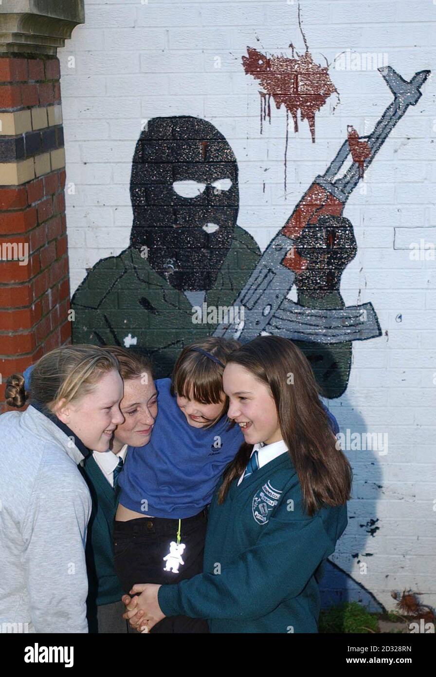 Le studentesse giocano di fronte a un murale dell'IRA nella zona dei mercati nazionalisti di Belfast. L'IRA ha annunciato di aver iniziato a smantellare le sue armi "per salvare il processo di pace" nell'Irlanda del Nord. * la mossa è arrivata 24 ore dopo che il presidente di Sinn Fein Gerry Adams ha detto di aver chiesto all'IRA di disarmare e prevenire il crollo dell'accordo del Venerdì Santo. Foto Stock